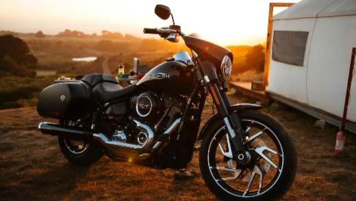 A Harley-Davidson motorcycle is parked under the beautiful sunset