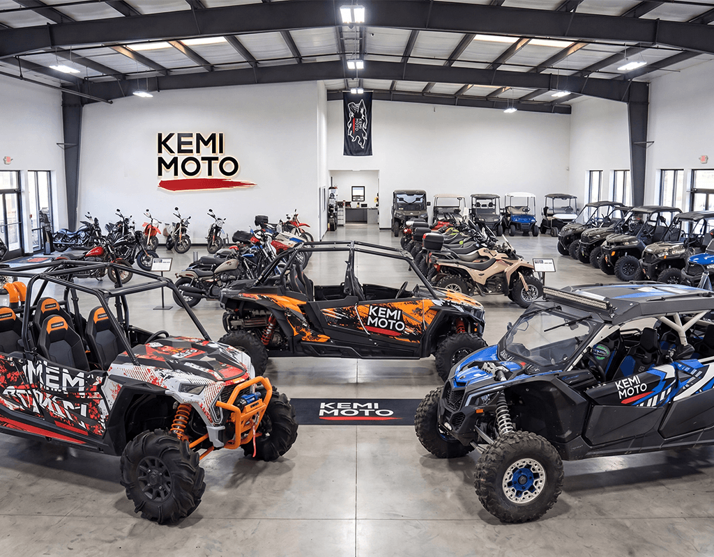 Kemimoto pro off-road garage showroom featuring a fleet of customized Polaris RZR and Can-Am Maverick vehicles for American terrain testing.