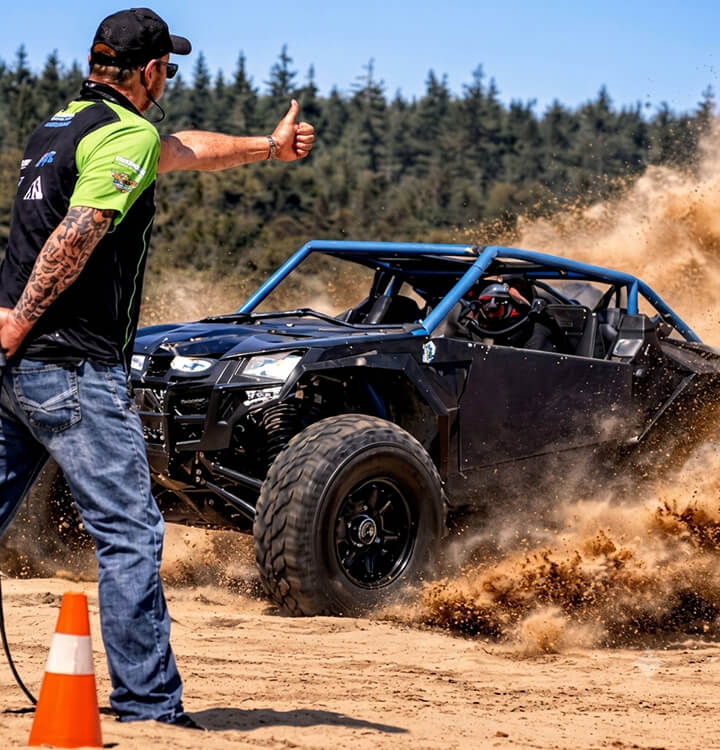 Battle-tested sport UTV drifting on a sandy trail during professional testing for the global riding community.